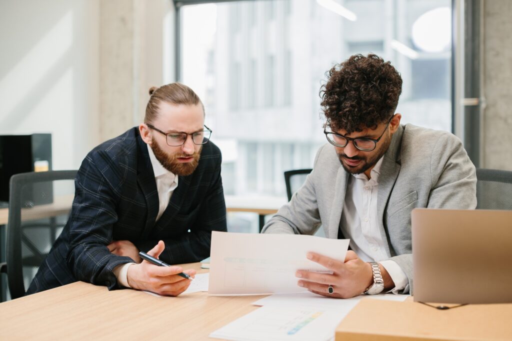 Businessmen working together analyzing financial documents in office